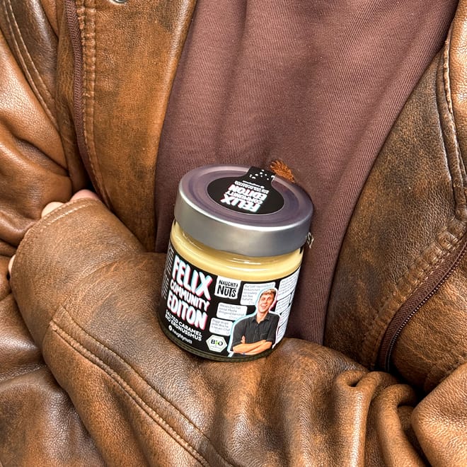 Felix Community Edition Erdnussmus Salted Caramel auf brauner Lederjacke