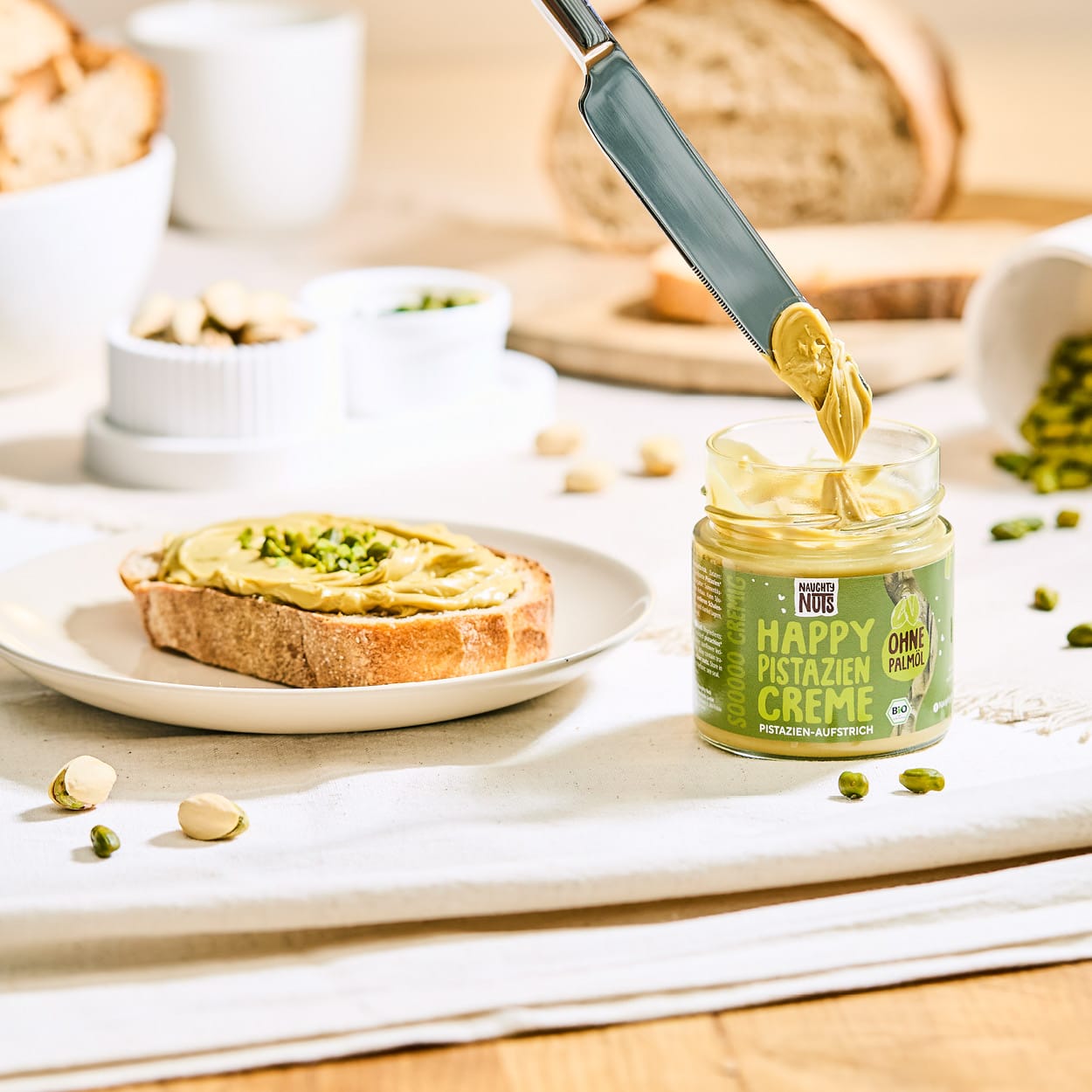 Happy Pistazien Creme auf Brot mit Messer und Pistazien